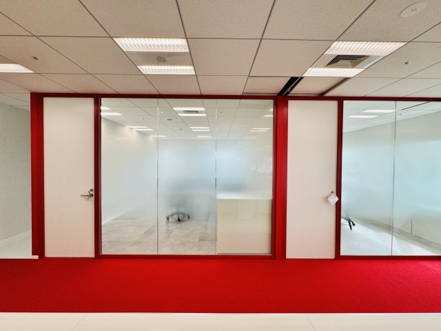 コーポレートカラーの赤を使用したオフィス内装