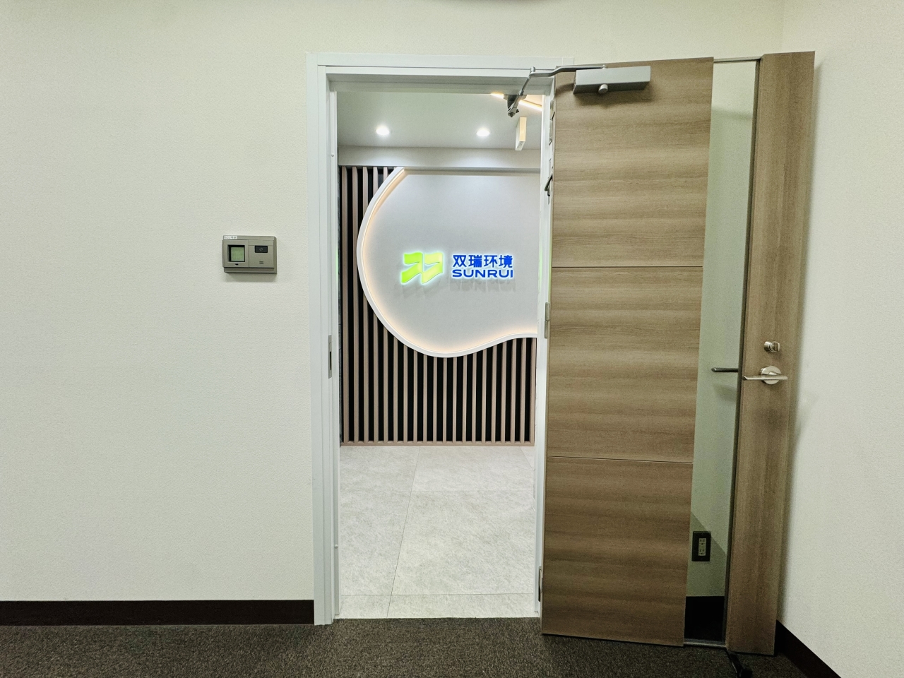 R曲線と木製ルーバー仕上げたオフィスエントランス